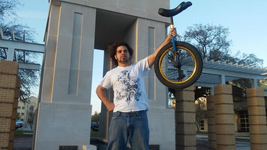 Senior Nicholas Squyres stands by the clock tower holding his unicycle.