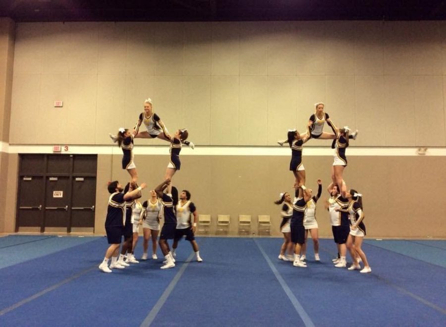The Wesleyan cheerleaders build pyramids during warm ups at the NAIA national competition. The pyramid on the left includes Zack Lanham, Isaac Johnson, and Ezekiel Johnson on the bottom.