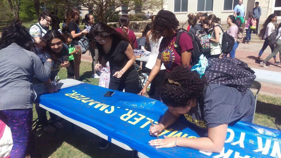 Students sign a banner thanking alumni for donating at the TAG Day event. The banner will be displayed at future alumni events.
Photo by Hannah Onder