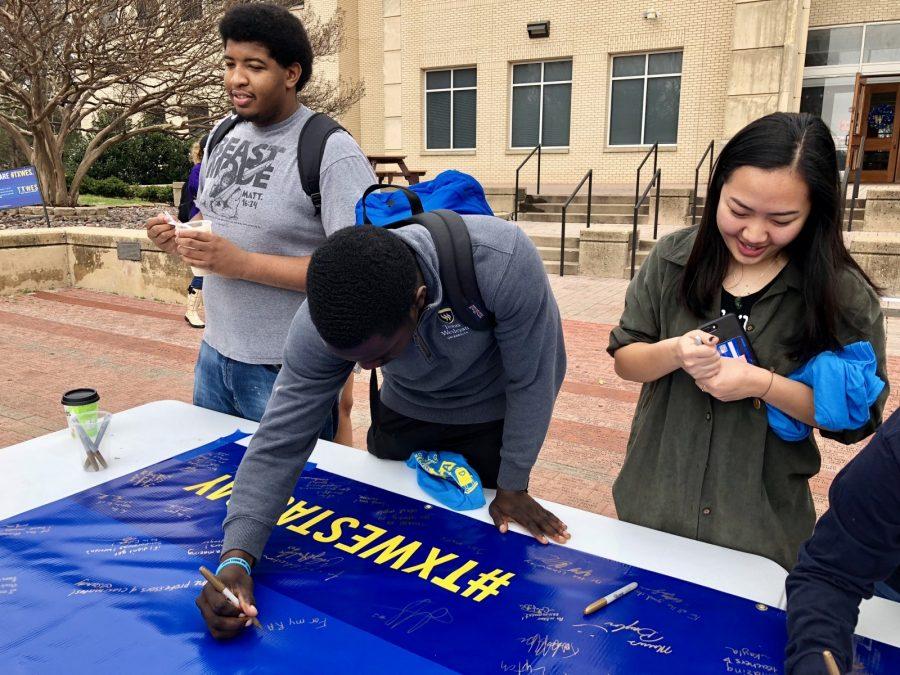 Junior criminal justice major Cameron Bennett signs the banner thanking donors at the T.A.G Day event at the campus mall.
Photo by Akeel Johnson