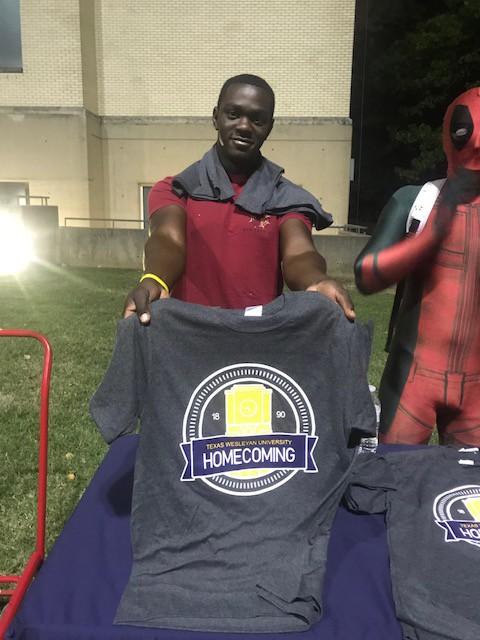 Cameron Bennett hands out shirts to students at the Midnight Breakfast.
Photo by Ashton Willis