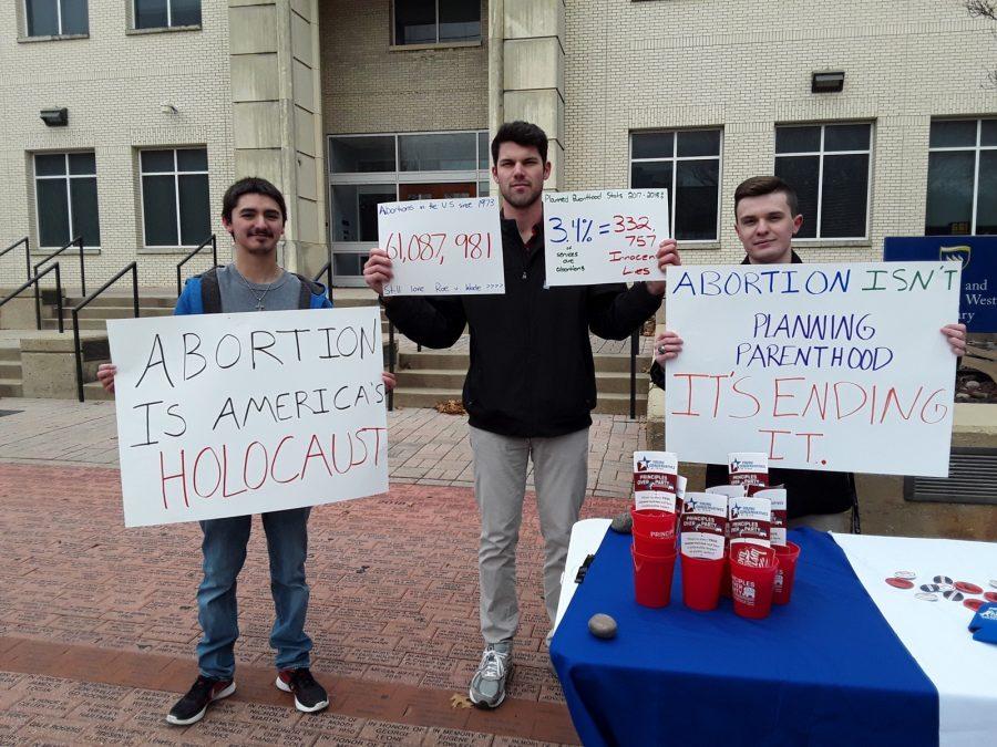Young Conservatives of Texas members Matthew Breedlove, Trace Lutteringer and Nicholas Davis protest outside the West Library.
Photo by Elizabeth Lloyd