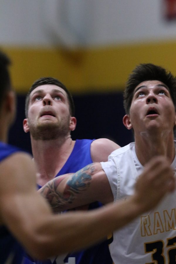 Sebastian Karwoski (in white) watches the rim in the first half of the Rams victory over John Brown University on Thursday night.
Photo by Lexi Barlow