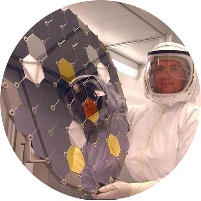 Dr. Eileen K. Stansbery in the Genesis Curator Clean Room dressed in a Dryden HEPA Filter suit holding a collector plate. The collector plate is an ultra-pure array composed of different materials used to extract solar wind atoms.

Photo is courtesy of NASA Johnson Space Center.
