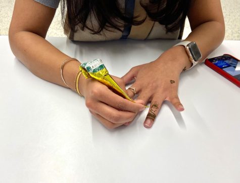 BSM member practices henna on her hand.