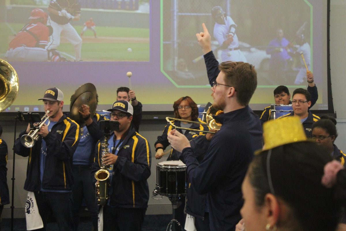 Rams band conductor Thomas Willmann directs musicians to play the school fight song at the pep rally.
