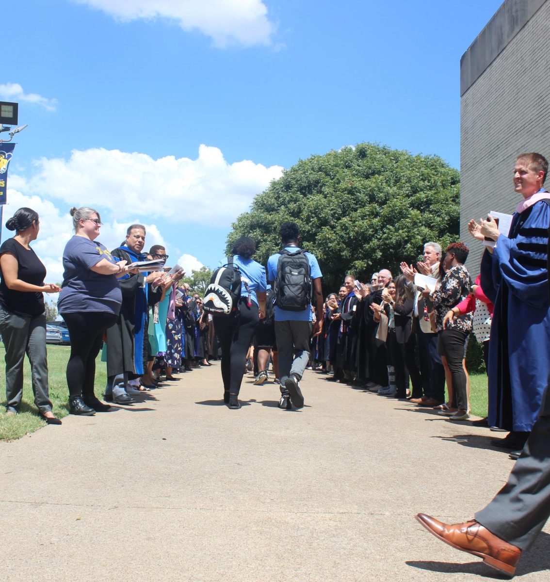 Faculty, senior administrators and trustees of Texas Wesleyan, clap and cheer during a walk out to celebrate the class of 2028. 