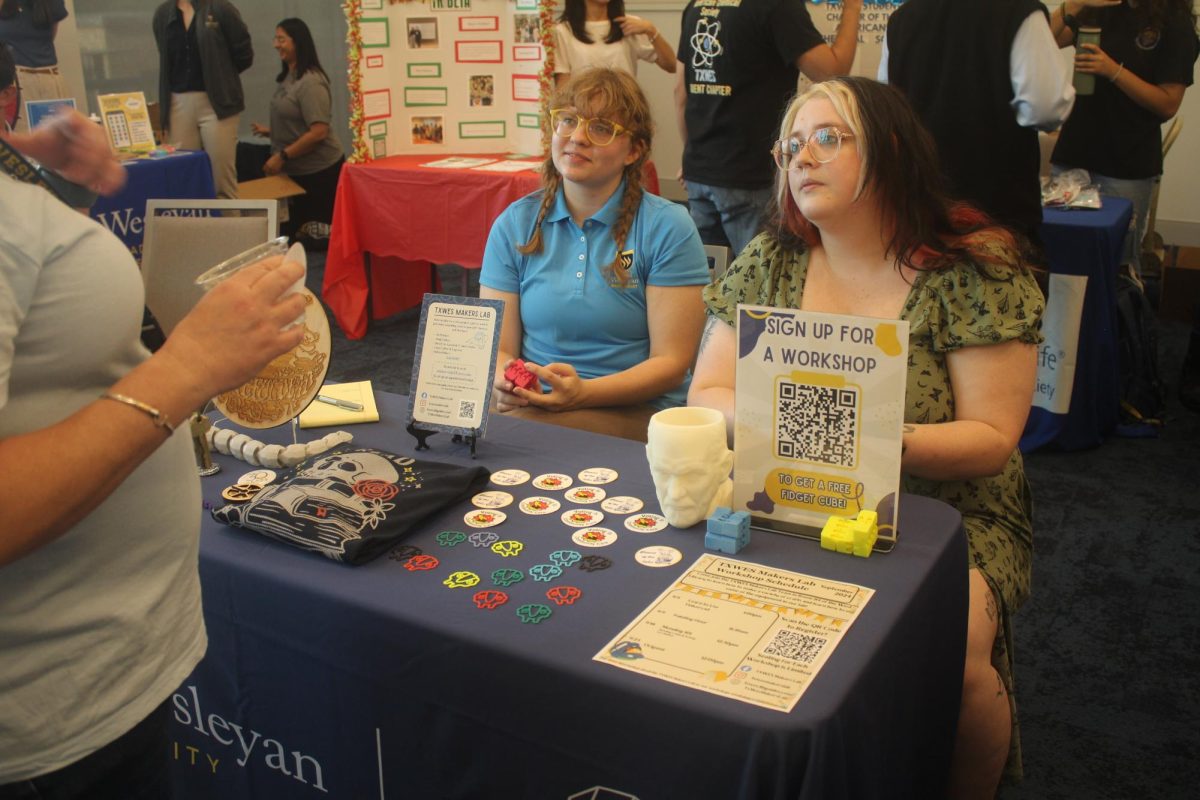 Leia Murray and Meagan Morris with the Makers Lab show 3D printed items such as sculptures and ram clips, buttons and a screen-printed sweater. To encourage students to sign up for workshops, they offered attendees a free fidget cube. 