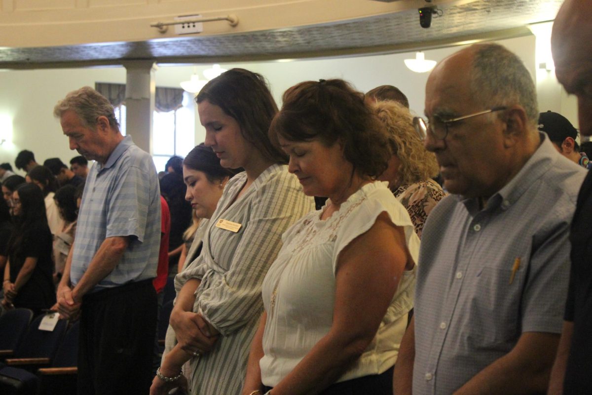 Attendees bow their heads in prayer as Dr. Gladys Childs, university Chaplin, leads the invocation. 