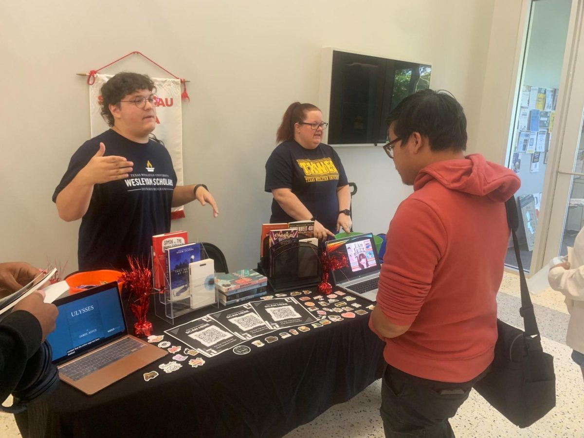 Sigma Tau Delta members Cameron Dudzinski and Susan Eliason inform a student on the banned book movement.