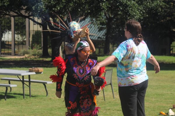 Junior liberal studies major Karina Orona Karina Orona (center) performs the Popoxcomitl [cleansing] on Latinx Heritage committee member Bertie Gardner (right).